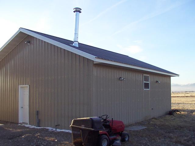 Wide view standing NW of the shop, looking SE.  The vent for the 200k BTU heater is visible, the two motion lights to the West, 