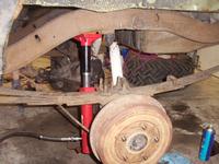 Rear brakes installed.  Using the porta-power to droop the suspension to fix the leaf spring clamp visible to the right