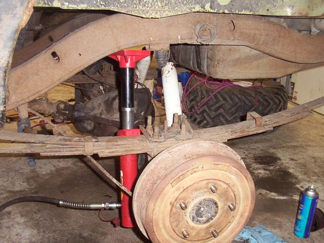 Rear brakes installed.  Using the porta-power to droop the suspension to fix the leaf spring clamp visible to the right